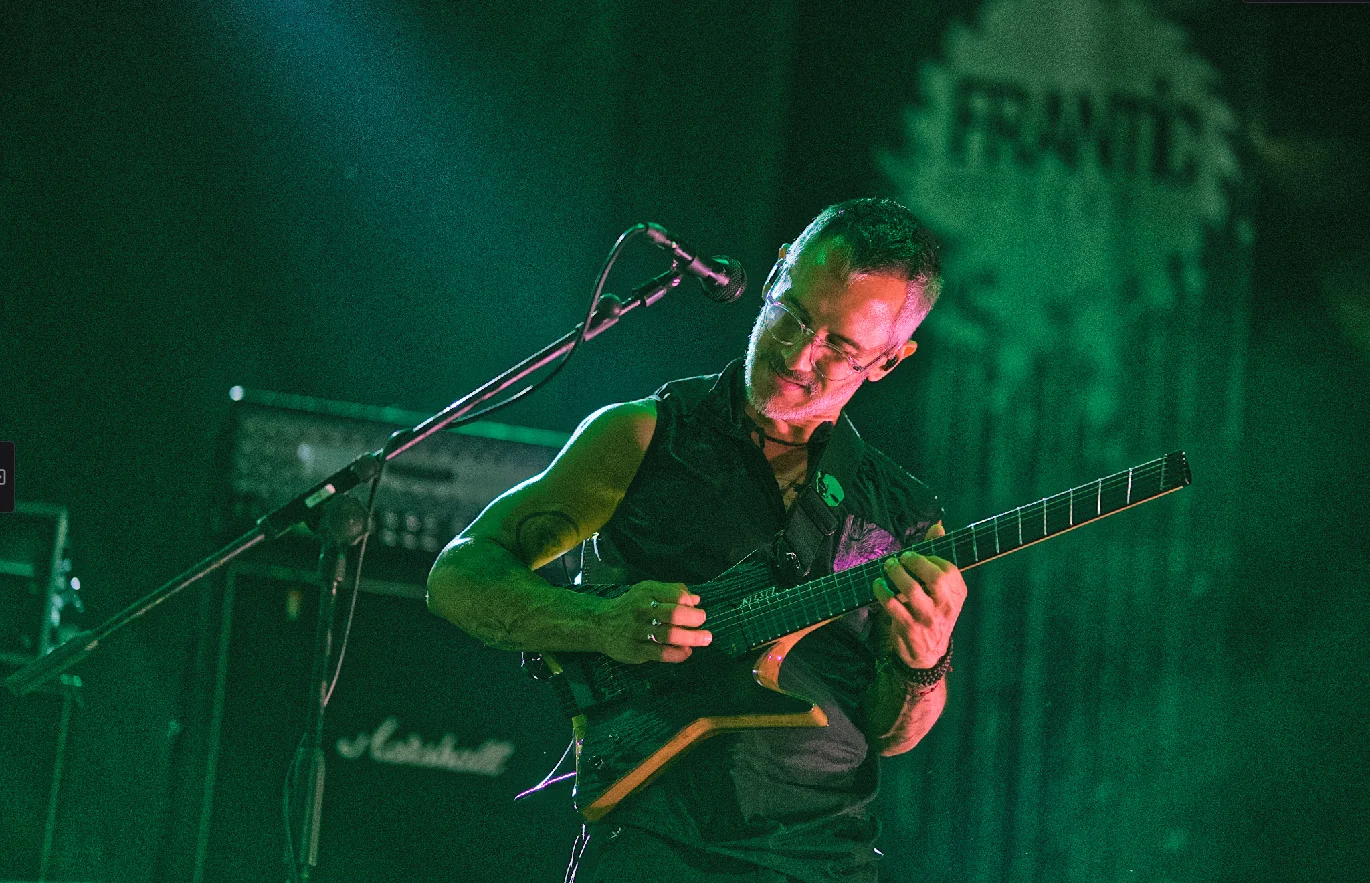 Guitarist on a green-lit stage, ISO 2500, without noise reduction